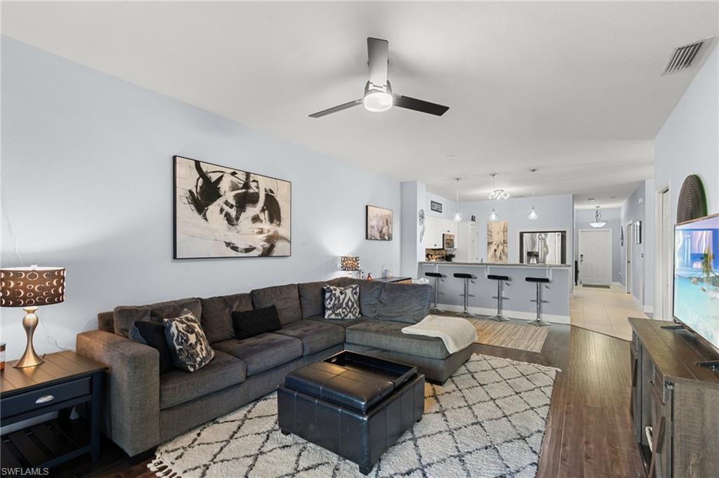 10021 Heather Lane, Unit 803 Naples, FL 34119 - Photo 13 of 41 a living room with furniture a rug and a chandelier