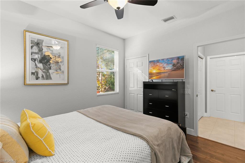 10021 Heather Lane, Unit 803 Naples, FL 34119 - Photo 19 of 41 a bedroom with a bed and a flat tv screen on dresser