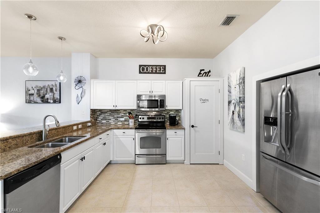 10021 Heather Lane, Unit 803 Naples, FL 34119 - Photo 4 of 41 a large kitchen with a refrigerator and a sink
