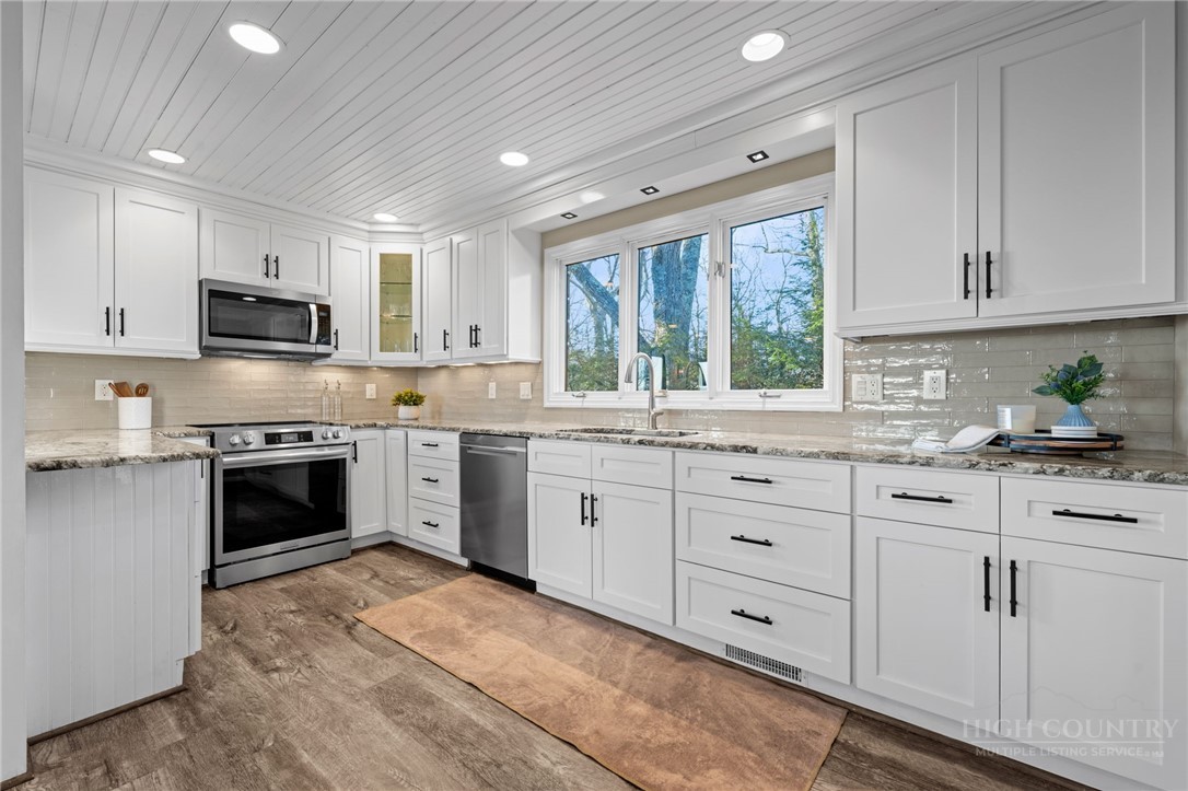 351 Windy Knob Trail Seven Devils, NC 28604 - Photo 7 of 50 a kitchen with granite countertop white cabinets and white stainless steel appliances