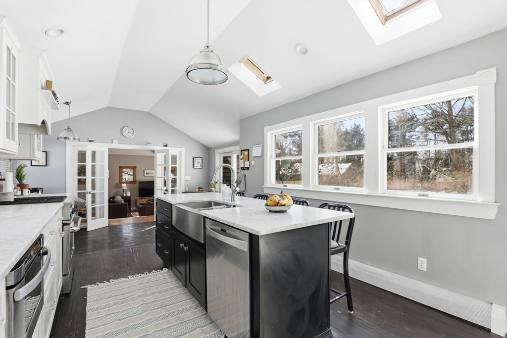327 Country Way Scituate, MA 02066 - Photo 11 of 39 a large kitchen with a stove a sink dishwasher a dining table and chairs with wooden floor