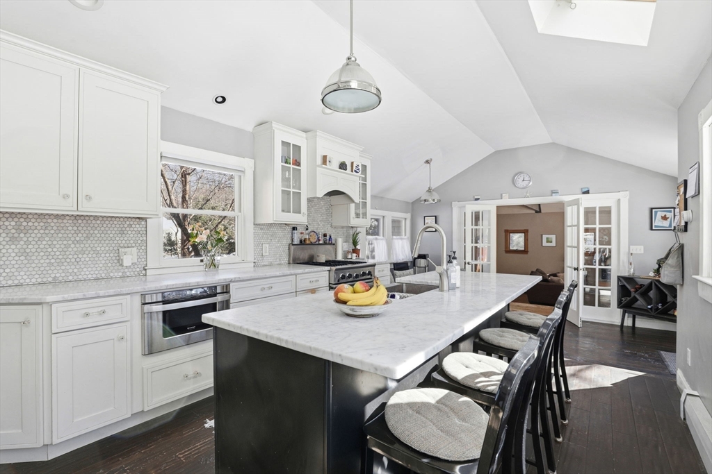 327 Country Way Scituate, MA 02066 - Photo 14 of 39 a kitchen with a sink a stove and chairs with wooden floor