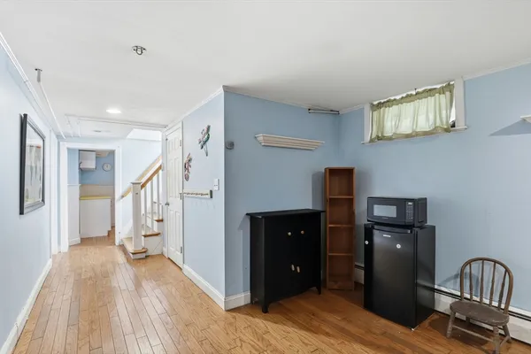 a view of a hallway with wooden floor and cabinet