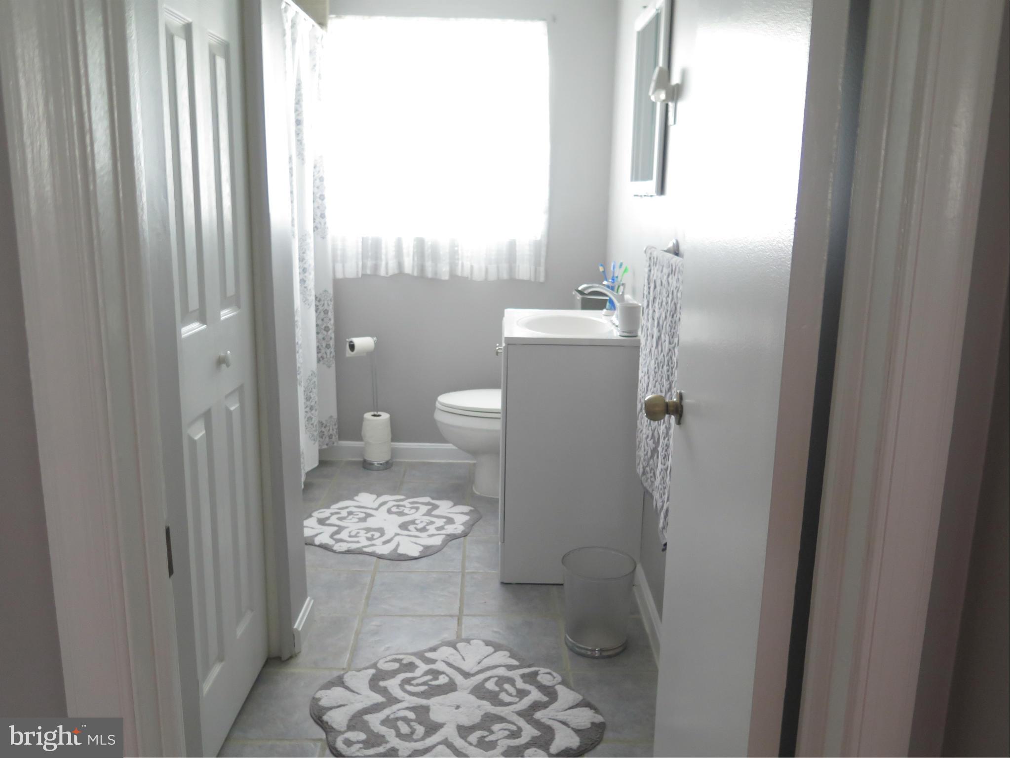 7867 Kavanagh Road Baltimore, MD 21222 - Photo 14 of 29 a bathroom with a granite countertop toilet a sink and a mirror