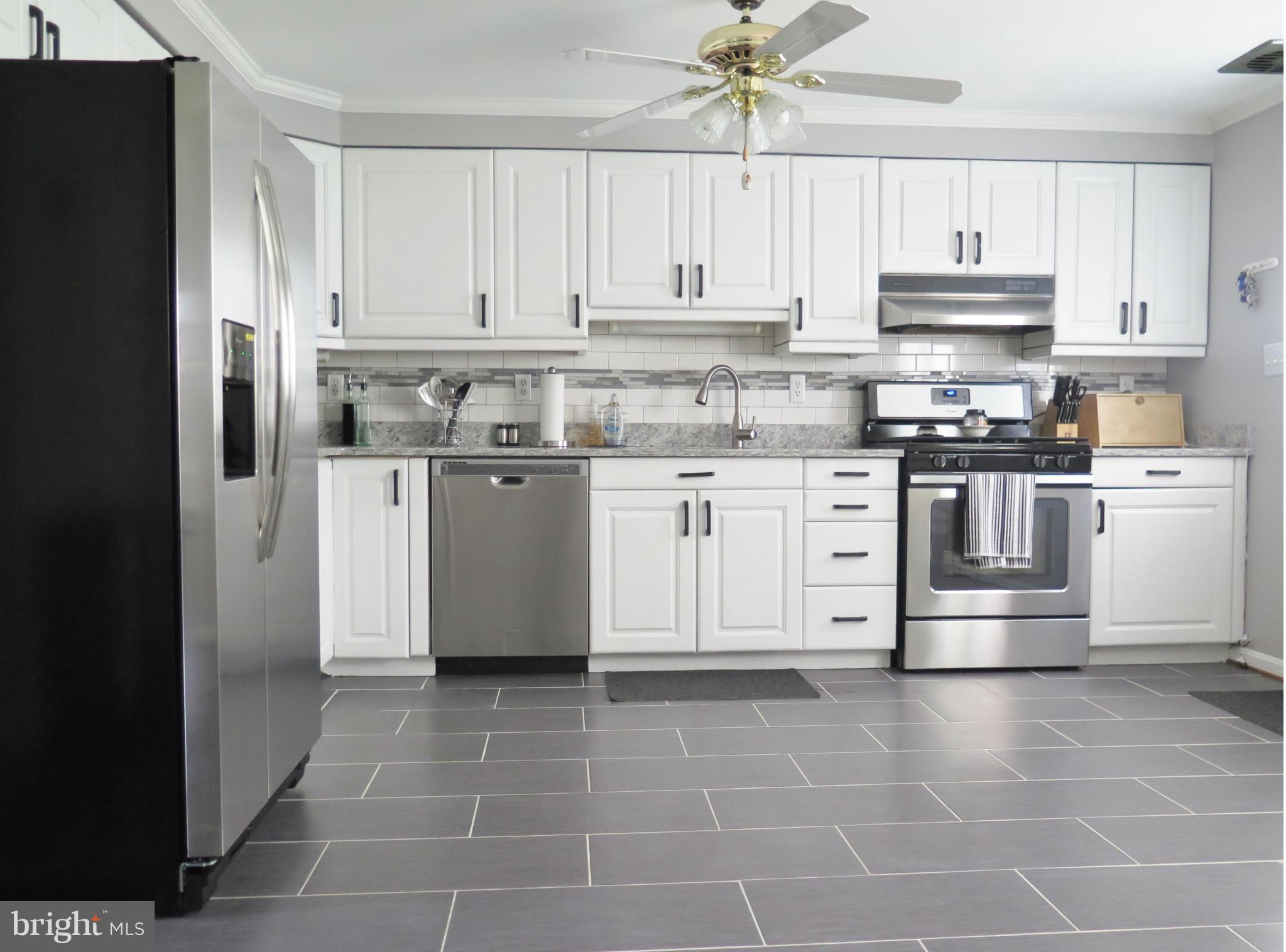 7867 Kavanagh Road Baltimore, MD 21222 - Photo 3 of 29 a kitchen with stainless steel appliances granite countertop a stove a refrigerator and a microwave