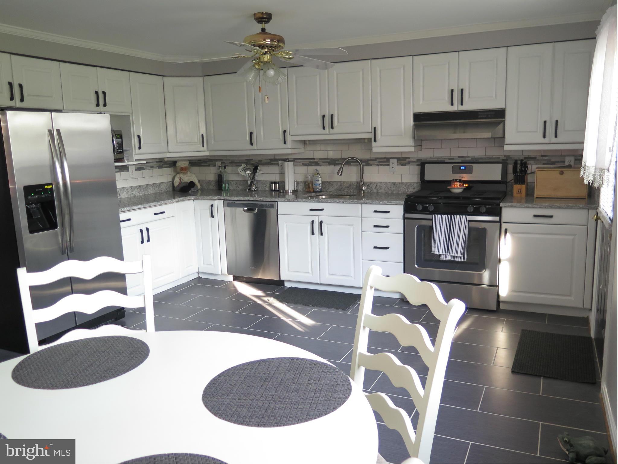 7867 Kavanagh Road Baltimore, MD 21222 - Photo 6 of 29 a kitchen with stainless steel appliances granite countertop a sink a stove a refrigerator and cabinets