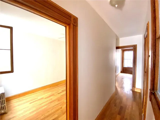 an empty room with a ceiling fan and wooden floor