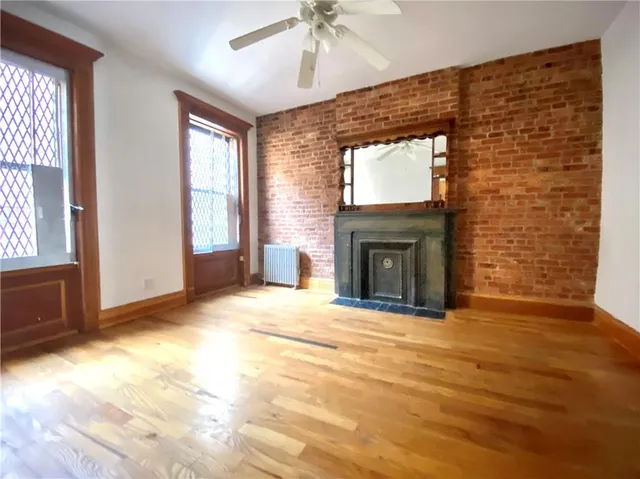 a view of a hallway with wooden floor and a fireplace