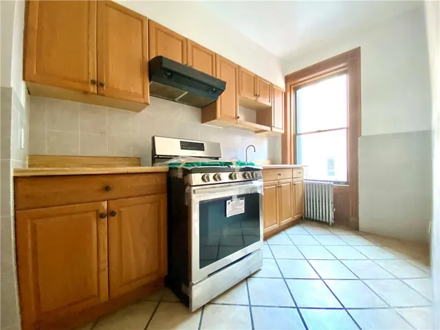 a view of an empty room with a fireplace and a window