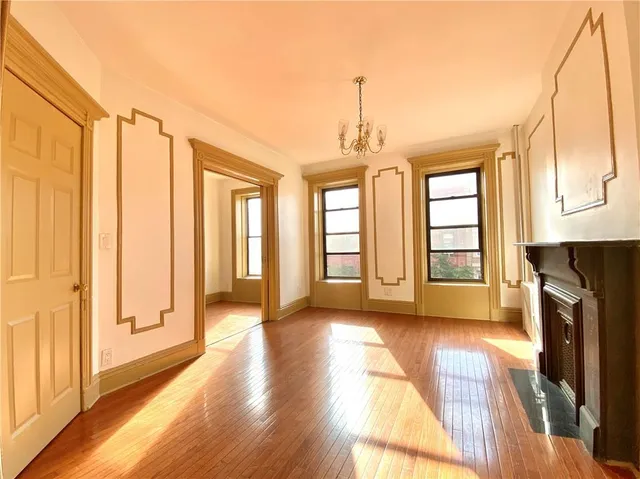 a spacious bedroom with a bed and a chandelier