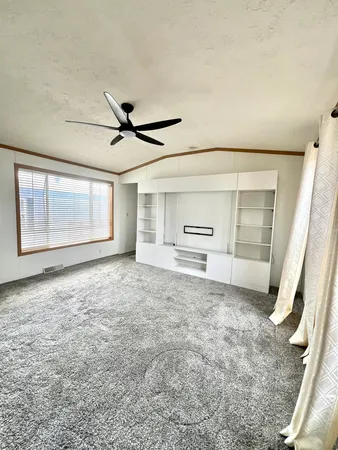 a view of a livingroom with a ceiling fan and window