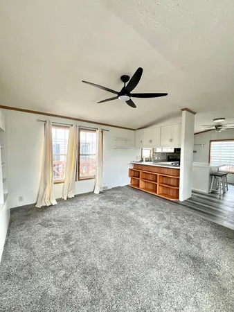 a view of a livingroom with furniture & a ceiling fan