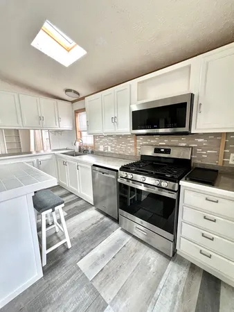 a kitchen with a stove a sink and a microwave