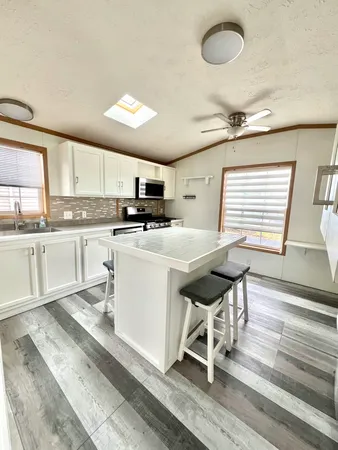 a kitchen with stainless steel appliances kitchen island granite countertop a stove a sink and a microwave
