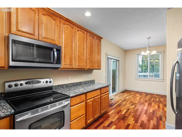 a kitchen with stainless steel appliances granite countertop a stove microwave and cabinets