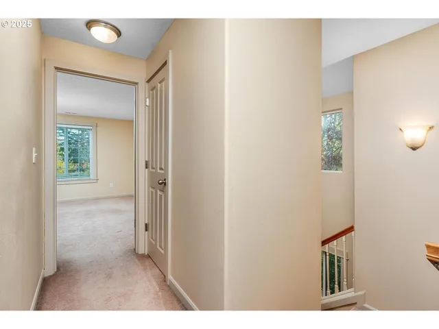 a view of a hallway with wooden floor and cabinet