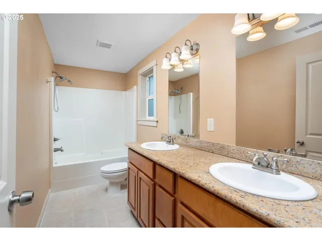 a bathroom with a granite countertop sink a toilet a mirror and bathtub