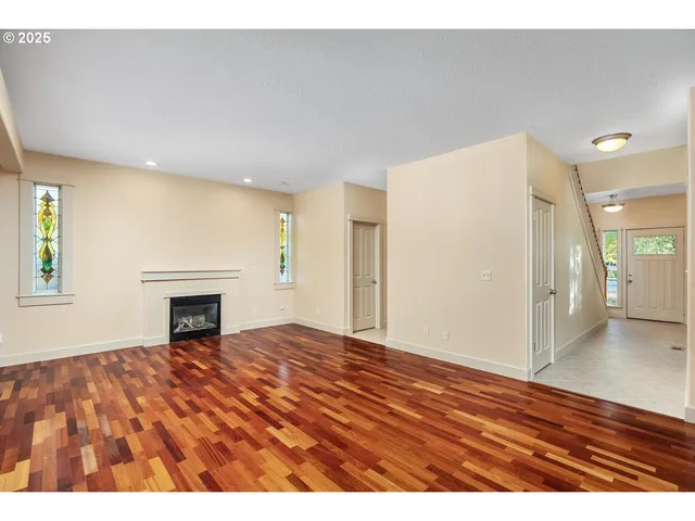 a view of an empty room with window and fire place