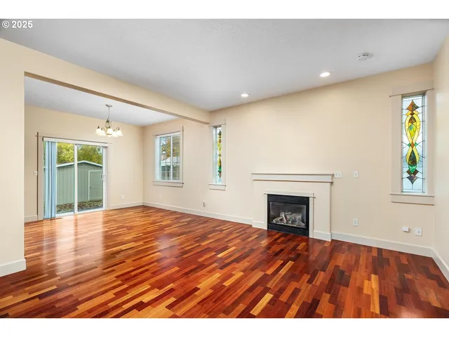 a view of empty room with wooden floor and fireplace
