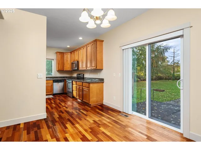 a open kitchen with stainless steel appliances granite countertop a stove a refrigerator a sink with dishwasher and wooden cabinets