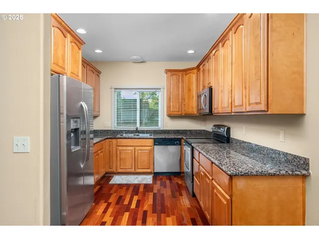 a kitchen view with granite countertop a sink stove and cabinets