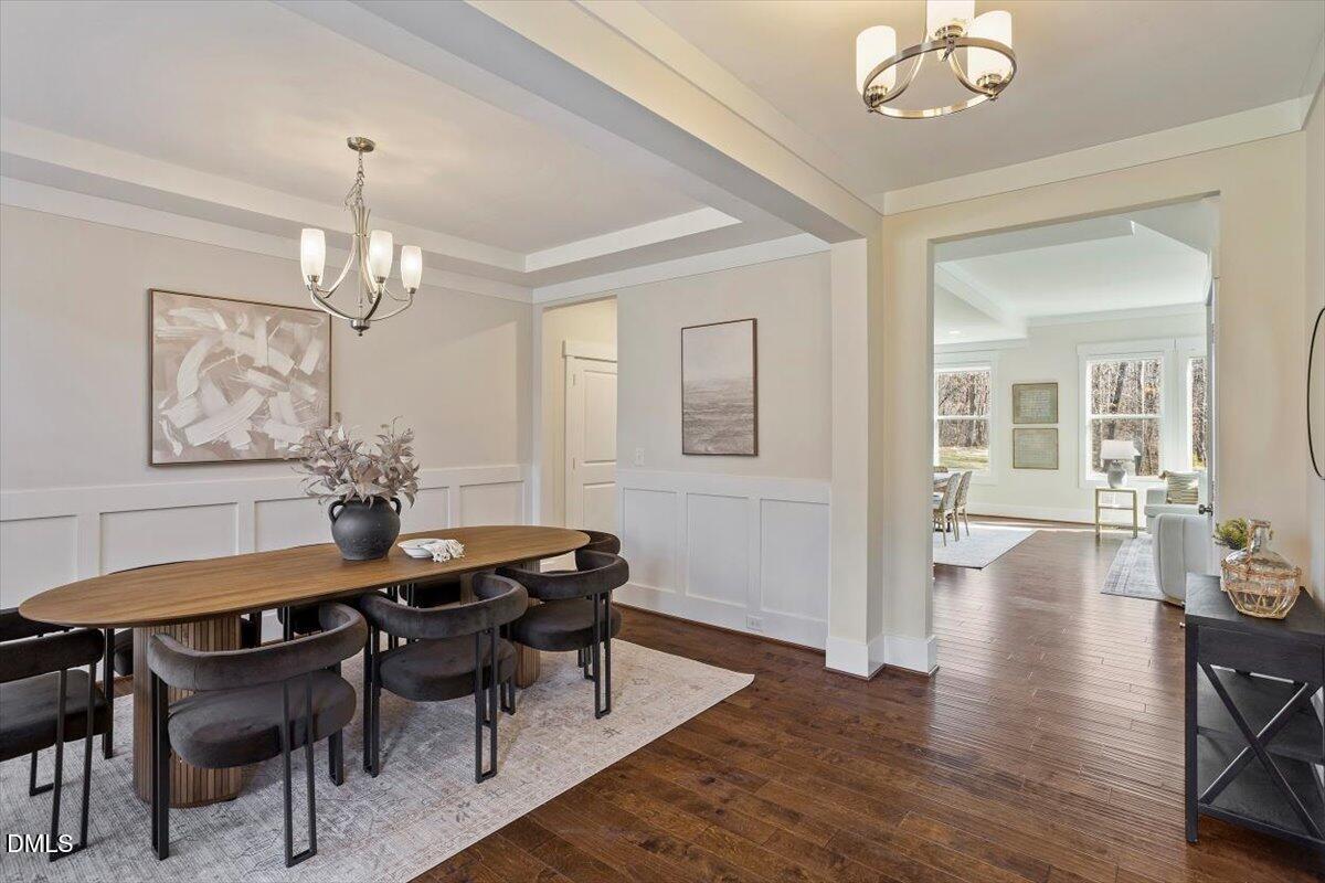 2301 Greenbrook Lane Durham, NC 27705 - Photo 12 of 42 a dining room with wooden floor a chandelier a wooden table and chairs