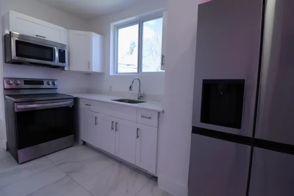 a kitchen with white cabinets stainless steel appliances and sink