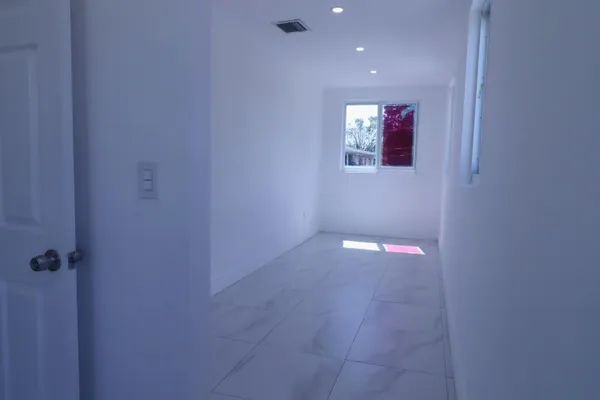 a hallway with stairs and a potted plant