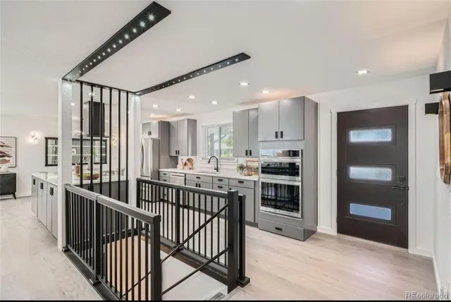 a kitchen with stainless steel appliances kitchen island granite countertop a refrigerator and a sink