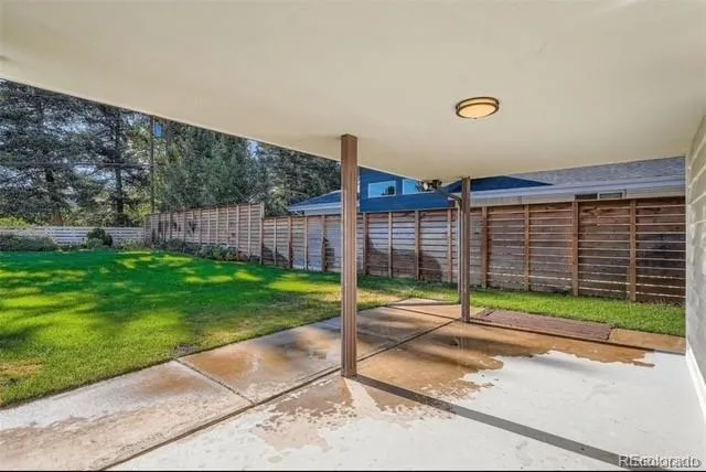 a view of a backyard with brick wall and plants