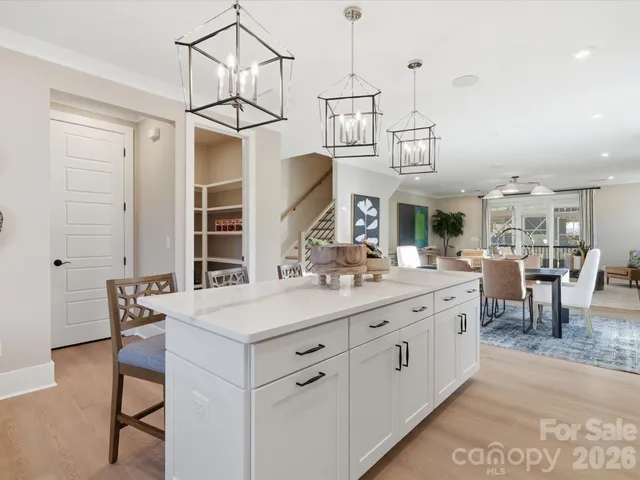 a kitchen with white cabinets and a large window