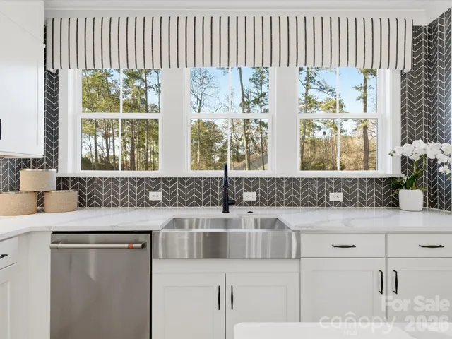 a living room with furniture a fireplace and a floor to ceiling window