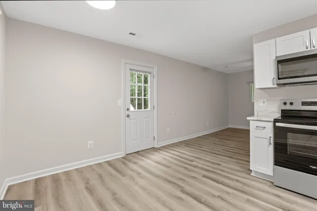 a view of a kitchen with wooden floor and electronic appliances