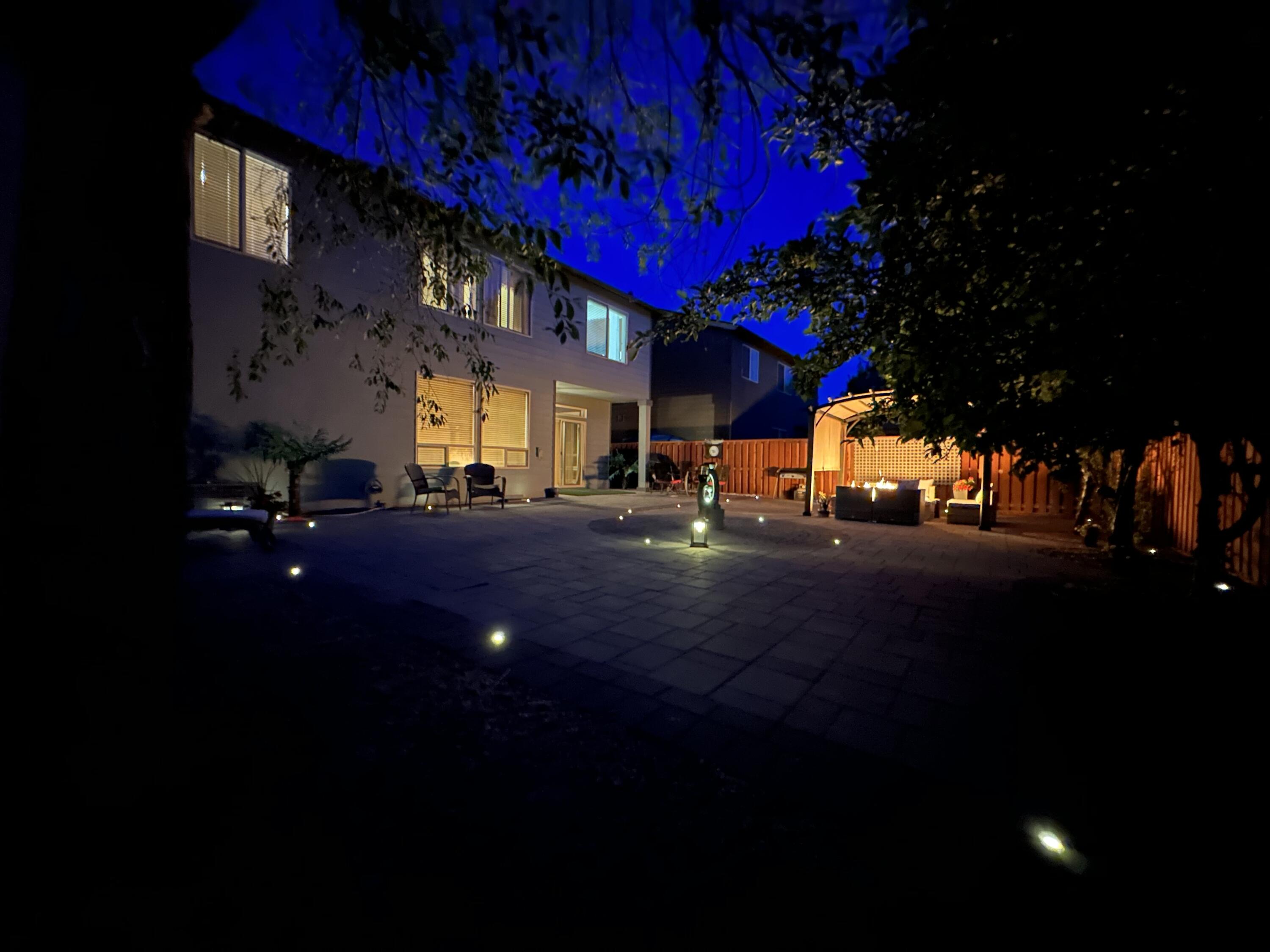 61235 Splendor Lane Bend, OR 97702 - Photo 6 of 52 Twilight Completely hardscape back yard with in ground lighting, built in gas fireplace, and elegant water feature.