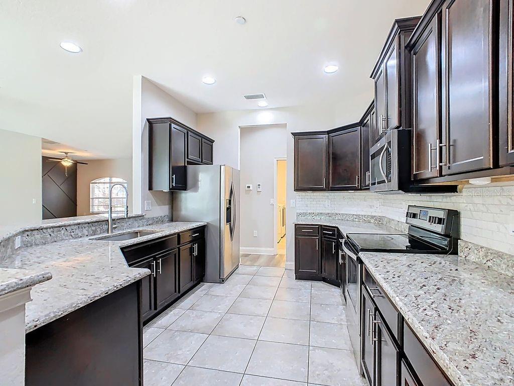 1918 Berry Road Plant City, FL 33567 - Photo 17 of 53 a kitchen with stainless steel appliances granite countertop a sink stove and refrigerator