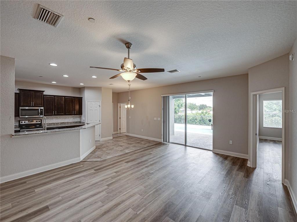 1918 Berry Road Plant City, FL 33567 - Photo 19 of 53 an empty room with wooden floor and kitchen view