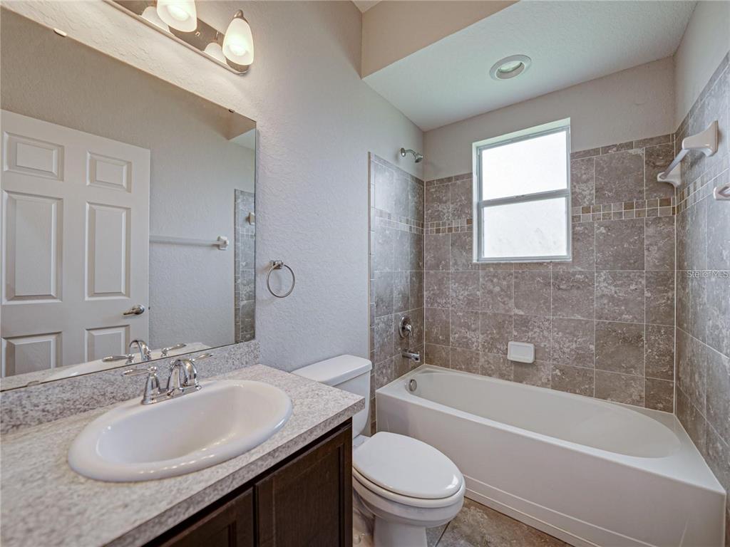 1918 Berry Road Plant City, FL 33567 - Photo 37 of 53 a bathroom with a granite countertop sink mirror toilet and bathtub