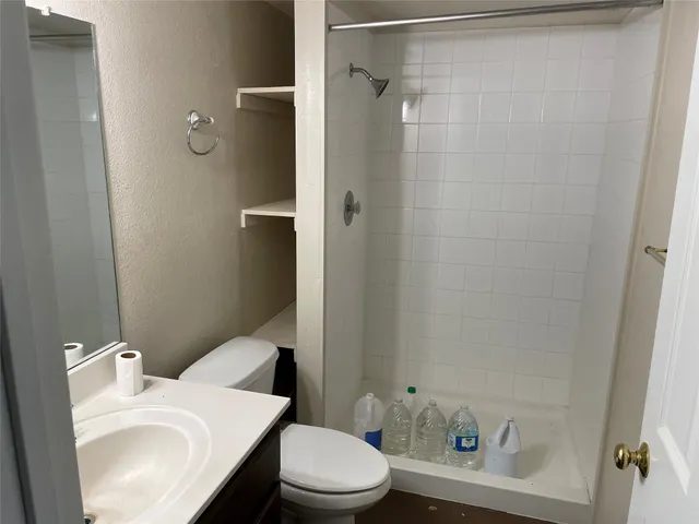 a bathroom with a sink a toilet and shower