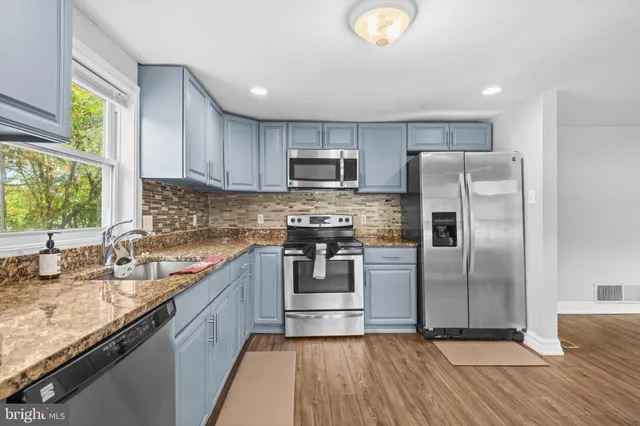 a kitchen with granite countertop a refrigerator and a sink