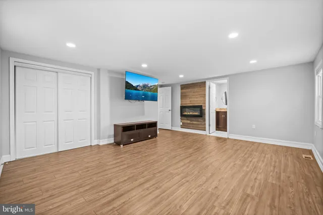 a view of empty room with wooden floor and fireplace
