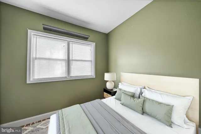 a bedroom with a bed and a window