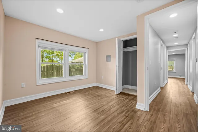 an empty room with wooden floor and a window