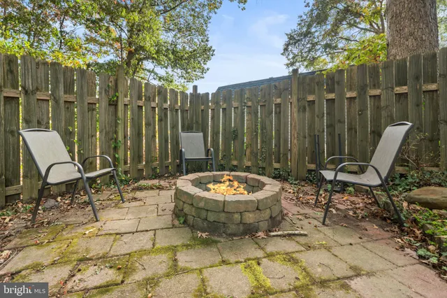 a backyard of a house with chairs and a fire pit