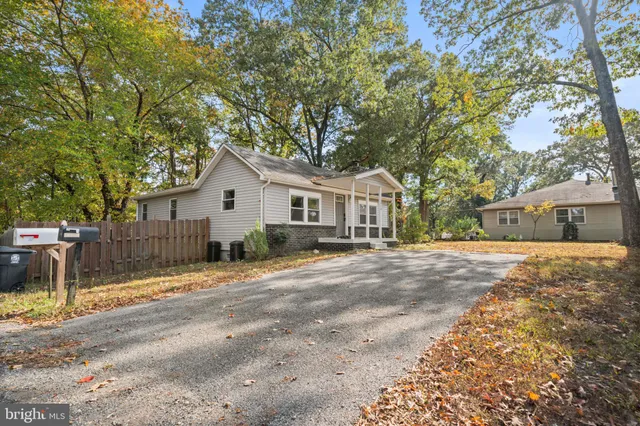 a view of a house with a yard and large tree