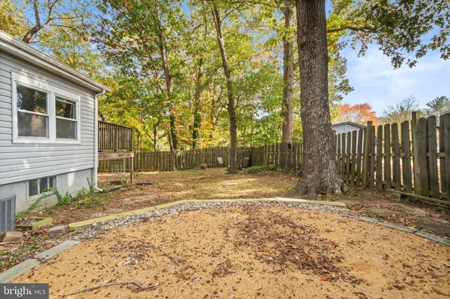 a view of a yard with wooden fence