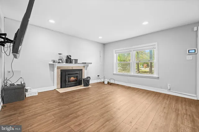 wooden floor fireplace and windows in an empty room