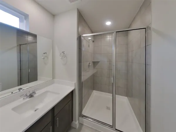 a bathroom with a shower sink vanity and mirror