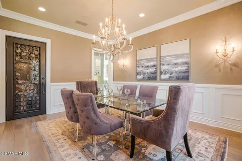 a dining room with furniture a chandelier and wooden floor