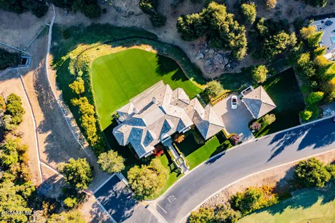 an aerial view of a house with a swimming pool and outdoor space