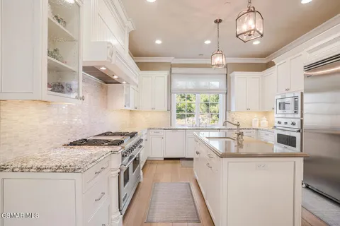 a kitchen with granite countertop a sink stove and cabinets